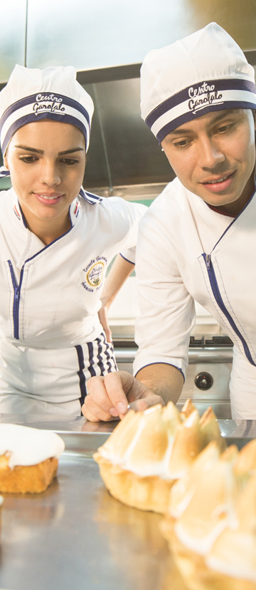 Dos alumnos observan con atención unos postres de merengue recién terminados.